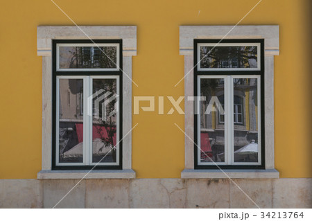 Two windows and a yellow facade 34213764