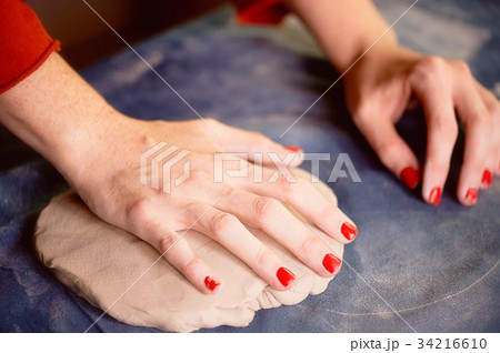 Master kneads lump of clay on the blue canvas Master kneads lump of clay on the blue canvas 34216610