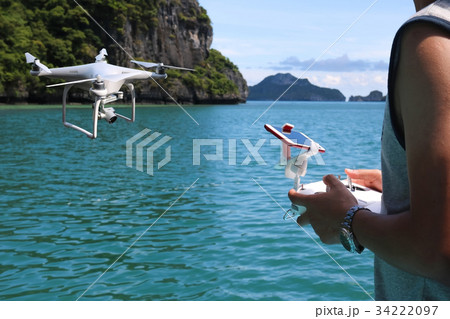 Men controlling drones camera on the beach Men controlling drones camera on the beach 34222097