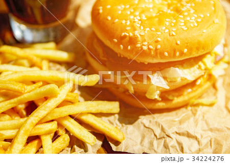Burger on craft paper with fries and coke on Burger on craft paper with fries and coke on 34224276