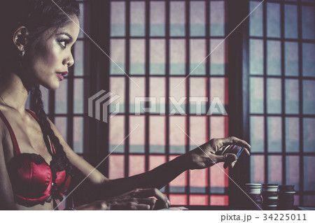 Sexy and happy female poker player 34225011
