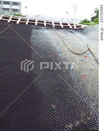 法面緑化のためにネットの上に生育基盤材を吹き付けます 法面緑化のためにネットの上に生育基盤材を吹き付けます 34230985