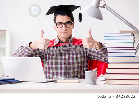 Super hero student wearing a mortarboard studying 34233022