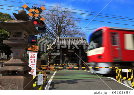 山門の前の踏切を通過する京急電車 34233397