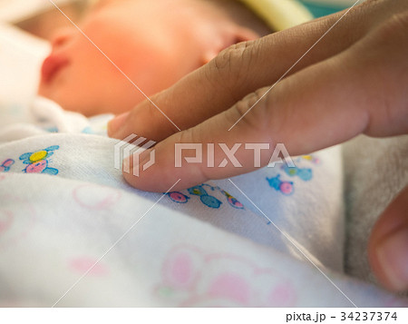 Mother's finger touches baby 34237374