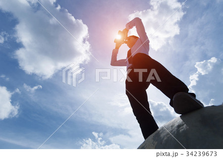 businessman standing under the sun and looking 34239673