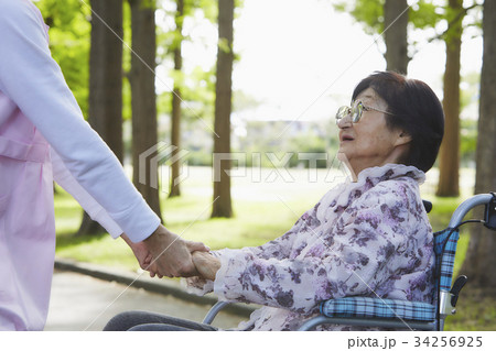 介護 車いすの女性と手をつなぐ 介護 車いすの女性と手をつなぐ 34256925