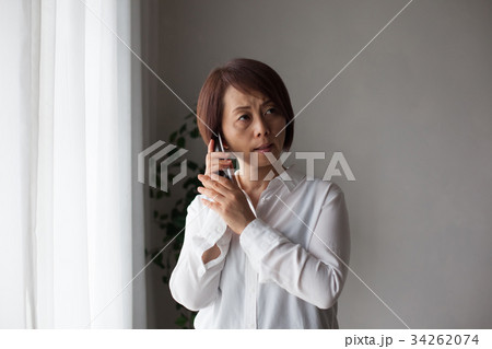 コードレス電話で話す女性（ネガティブ） 34262074