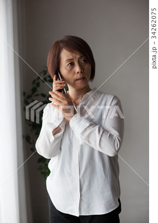 コードレス電話で話す女性（ネガティブ） 34262075