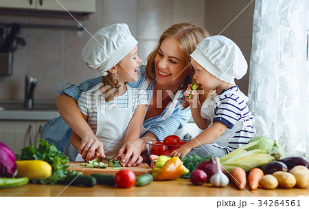 Healthy eating. Happy family mother and children prepares  vegetable salad. 34264561