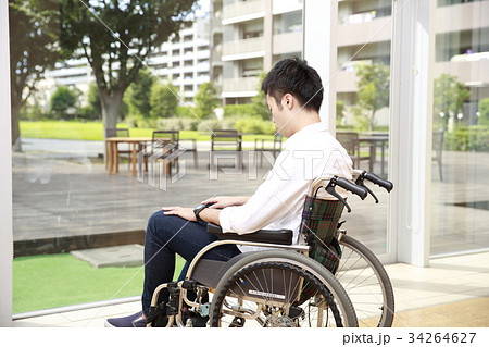 車いすに座り外を眺める若い男性 車いすに座り外を眺める若い男性 34264627