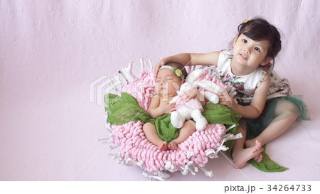 little girl looks at her baby sister. 34264733