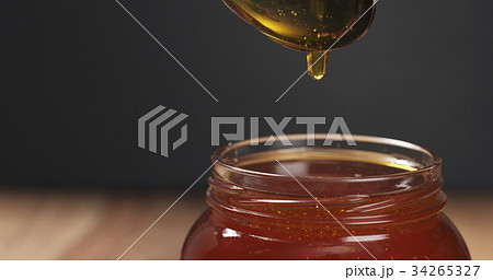 honey pour with spoon in glass jar honey pour with spoon in glass jar 34265327