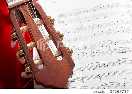 acoustic guitar on red fabric, closeup objects acoustic guitar on red fabric, closeup objects 34267757