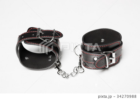 Black leather handcuffs on white background. Black leather handcuffs on white background. 34270988
