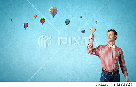 Guy looking in magnifying glass 34283824