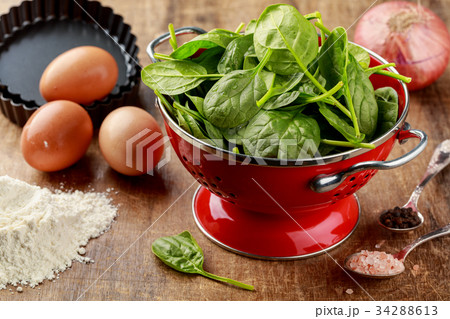Fresh spinach in red colander with ingredients  34288613