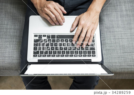 Man uses laptop on sofa in his home. High angle view, Work at h Man uses laptop on sofa in his home. High angle view, Work at h 34289259
