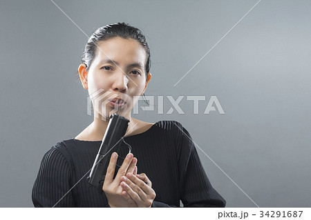 Portraits Asian woman smoke out of a gun in hand. Portraits Asian woman smoke out of a gun in hand. 34291687