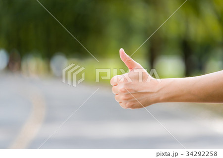 Close up woman hand hitchhiking at countryside Close up woman hand hitchhiking at countryside 34292258