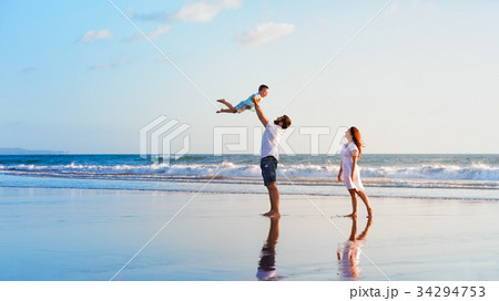 Family - father, mother, baby walk on sunset beach Family - father, mother, baby walk on sunset beach 34294753