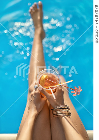 Girl's legs over swimming pool outdoors 34297079