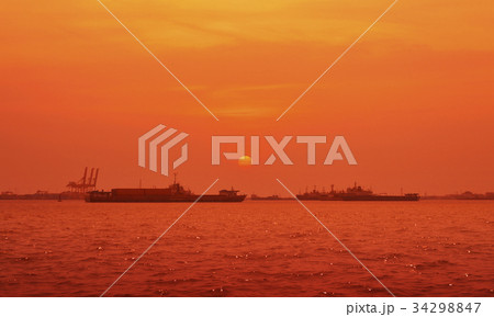 Cargo ship with shipping port over sunset sea Cargo ship with shipping port over sunset sea 34298847