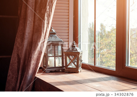 Window sill with lanterns and candles. Interior Window sill with lanterns and candles. Interior 34302876