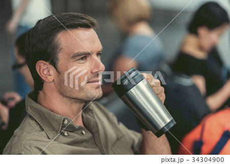 Cheerful cute guy is enjoying his beverage 34304900