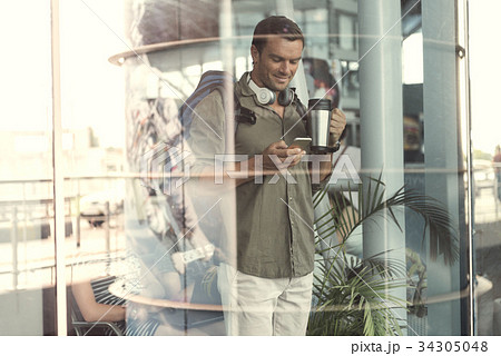 Positive guy is holding mobile phone with smile 34305048
