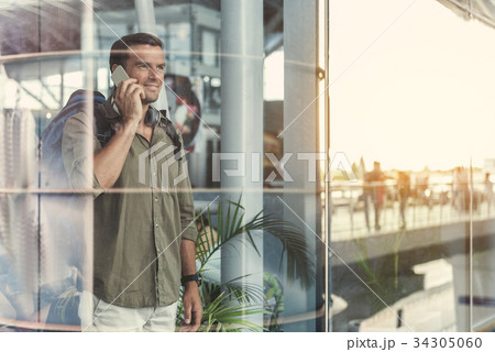 Joyful guy is having conversation on smartphone Joyful guy is having conversation on smartphone 34305060