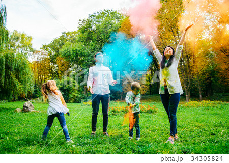 cute european family plaing with holi paints in cute european family plaing with holi paints in 34305824