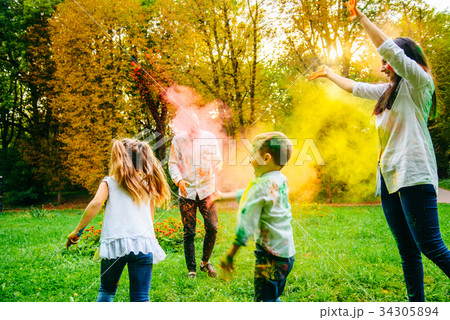 cute european family plaing with holi paints in 34305894