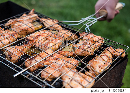 Man is turning cooking grill with chicken 34306084