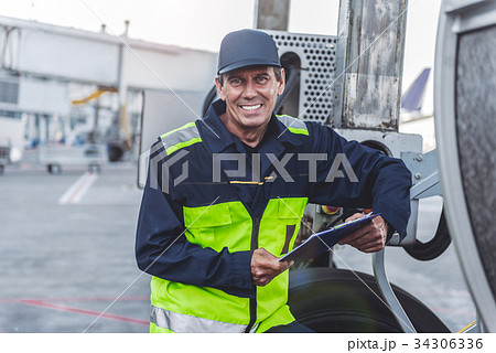 Cheerful technical staff working at airport Cheerful technical staff working at airport 34306336