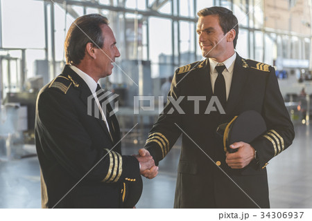 Beaming pilots clasping arms at airdrome Beaming pilots clasping arms at airdrome 34306937