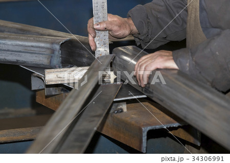 Metalworking shop workers work behind machines and Metalworking shop workers work behind machines and 34306991
