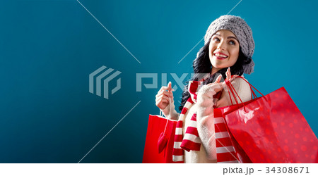 Happy young woman holding shopping bags  34308671