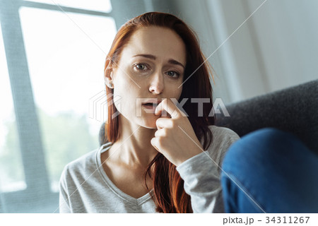 Unhappy nervous woman biting her nail 34311267
