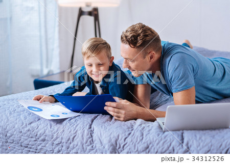 Caring father helping son with his school project 34312526