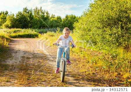 Smiling little girl on a bicycle 34312571