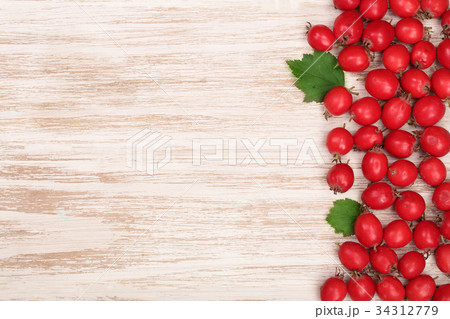 Hawthorn berry with leaves on a white wooden 34312779