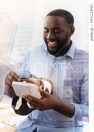 Amused man keeping virtual glasses in hands 34312942