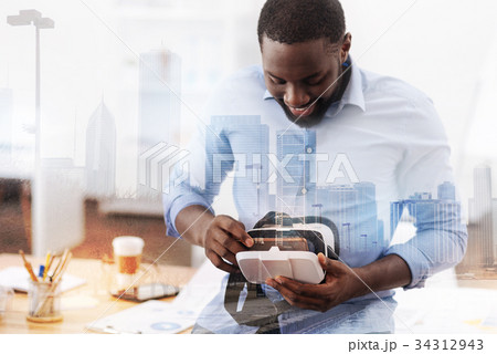 Concentrated man holding virtual glasses 34312943