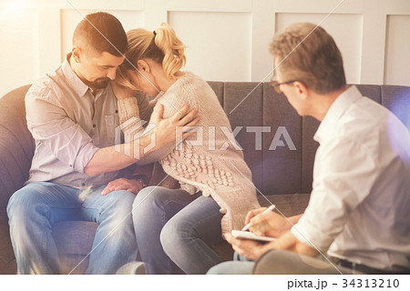 Unhappy nice man hugging his wife Unhappy nice man hugging his wife 34313210