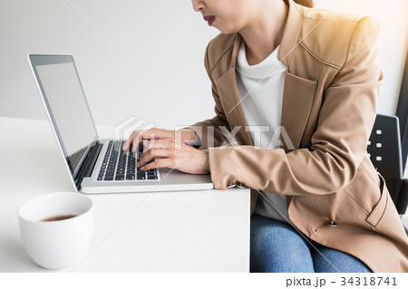Attractive women in casual business sitting at a table working o Attractive women in casual business sitting at a table working o 34318741