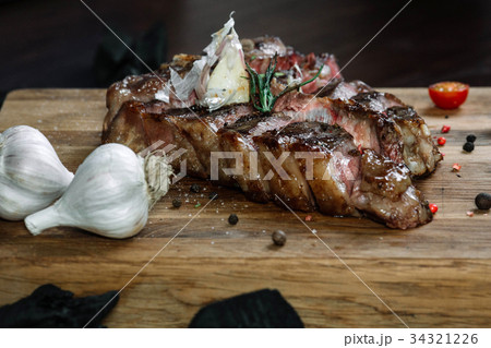 Sliced grilled T-bone steak on a cutting board Sliced grilled T-bone steak on a cutting board 34321226