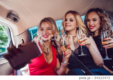 Pretty women having party in a limousine car 34322472