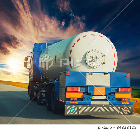 White tanker and trucks driving along the asphalt 34323125