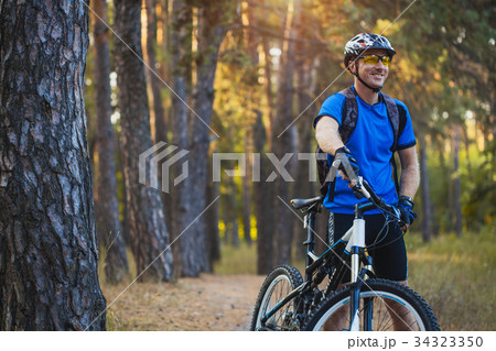 man cyclist rides in the forest on a mountain bike man cyclist rides in the forest on a mountain bike 34323350